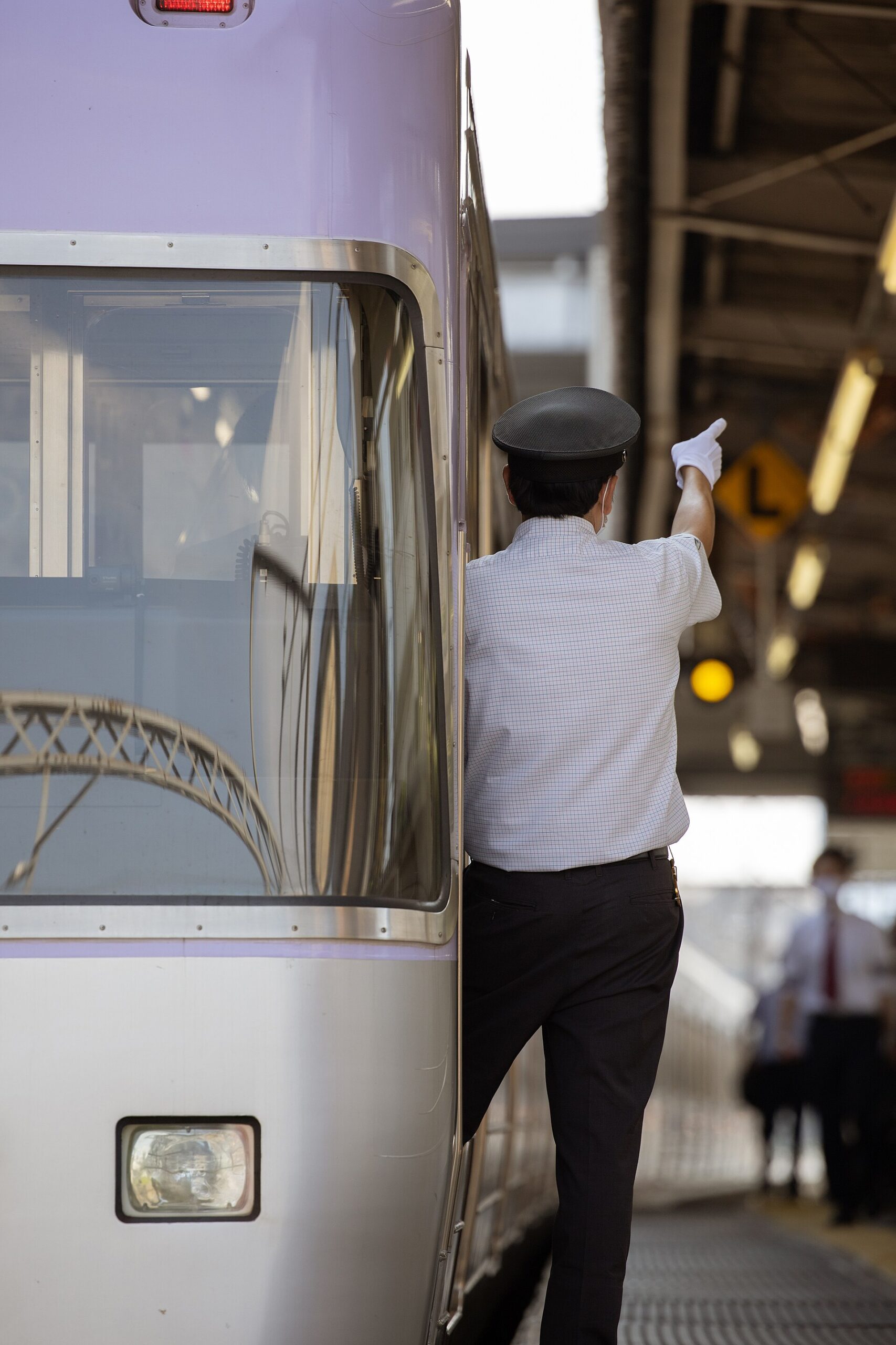 A Keio Inokashira Line conductor pointing at Shimo-Kitazawa Station