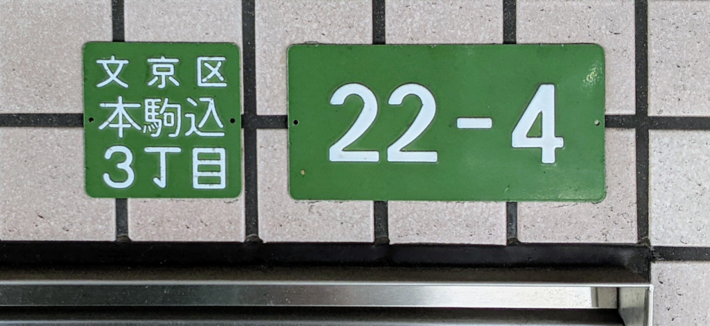 Tokyo residence address plates showing Bunkyo Ward, Honkomagome 3-chome, block 22 and residence number 4