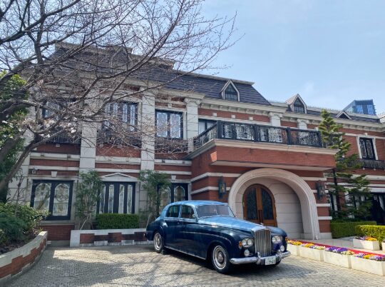 南平台の洋館風建築と玄関前のクラシックカー