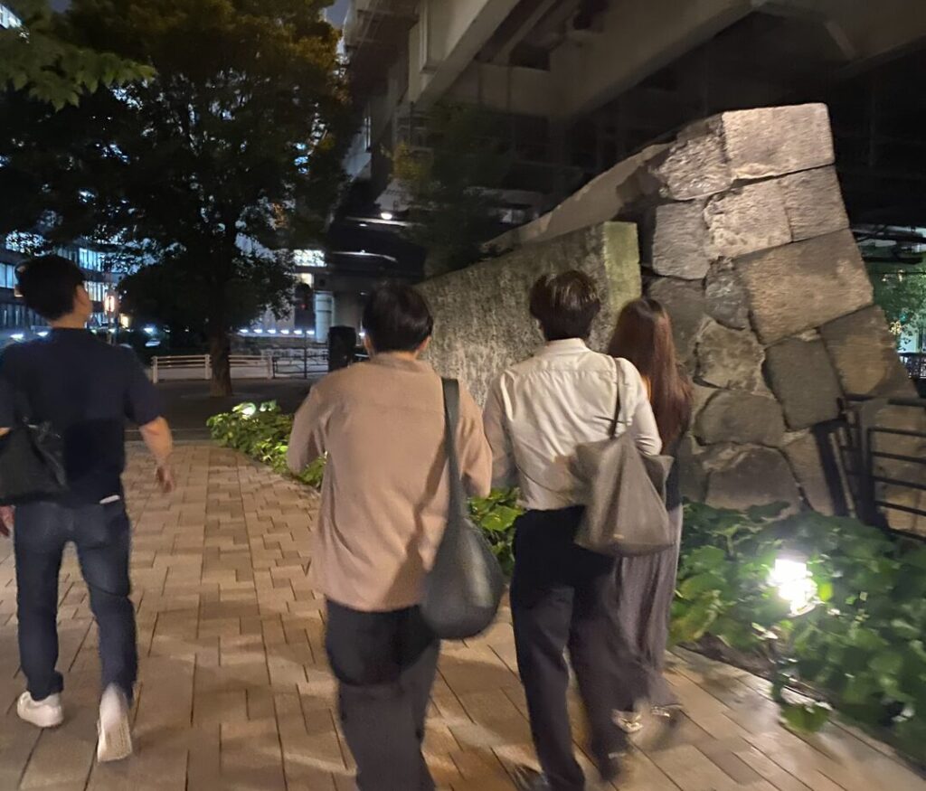 一橋門跡付近の石垣を見ながら歩く参加者