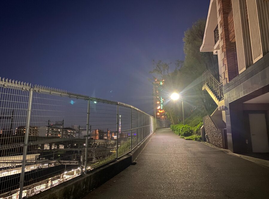 夜の田端駅南口付近で線路沿いの坂道と街明かりを望む風景