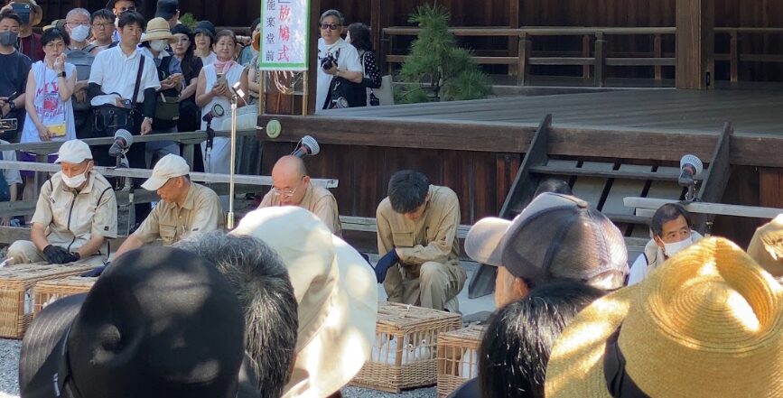 靖国神社の放鳩式開始を待つ参列者と鳩籠