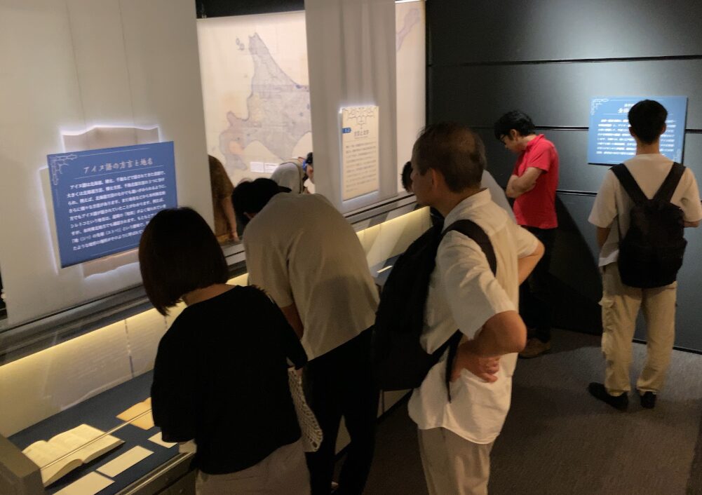 アイヌモシㇼ展の展示資料を鑑賞する参加者