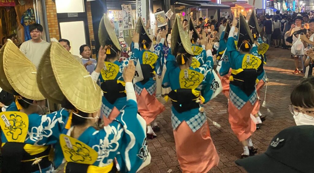 東京高円寺阿波おどりで青と桃色の衣装の連が踊る様子