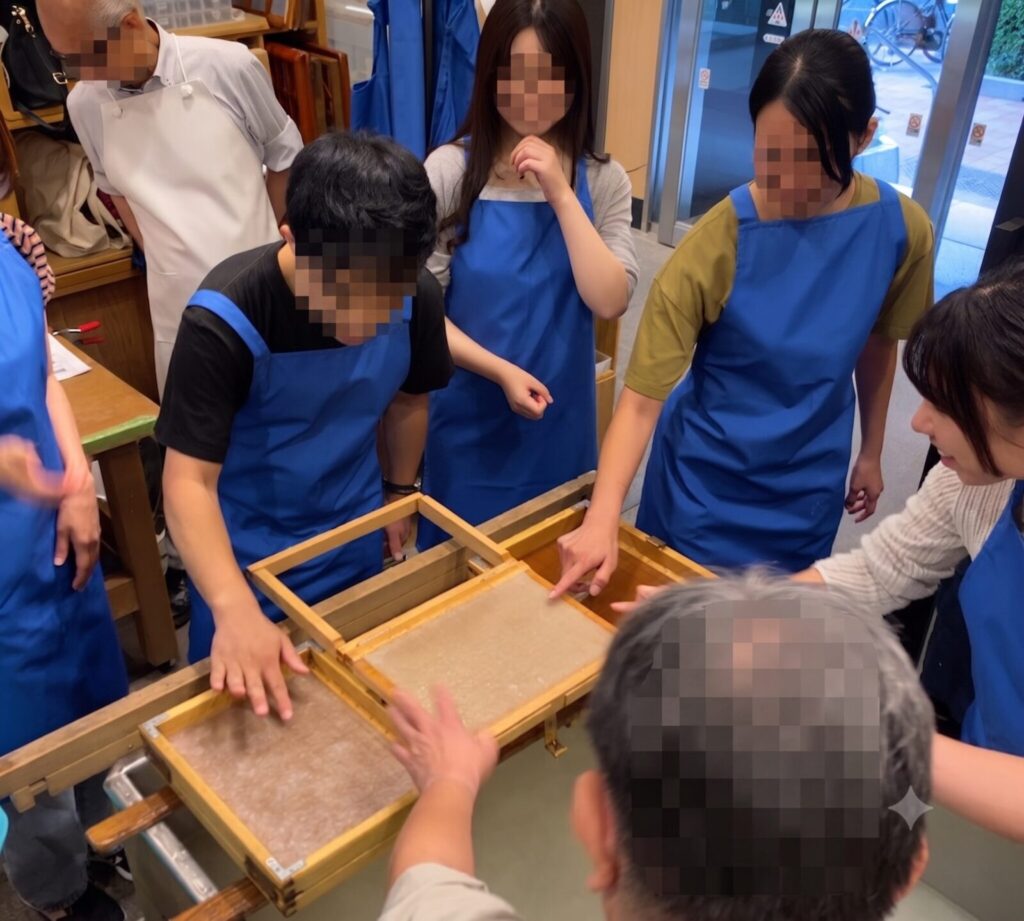 小津和紙の手漉き和紙体験で紙料をすくう参加者