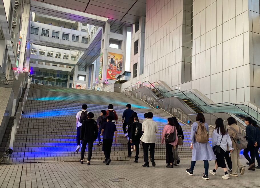 フジテレビ本社屋の大階段を上るゆる歴史散歩会の参加者