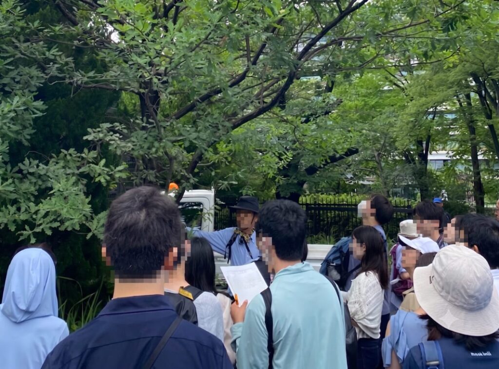 猿江恩賜公園の自然観察会で樹木医の解説を聞く参加者たち