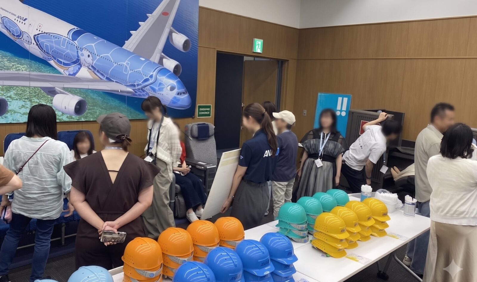 ANA Blue Hangar Tourのお話し会場で色分けされたヘルメットを受け取る参加者たち