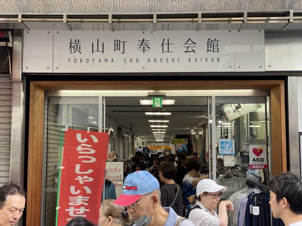 横山町奉仕会館の入口に集まる買い物客