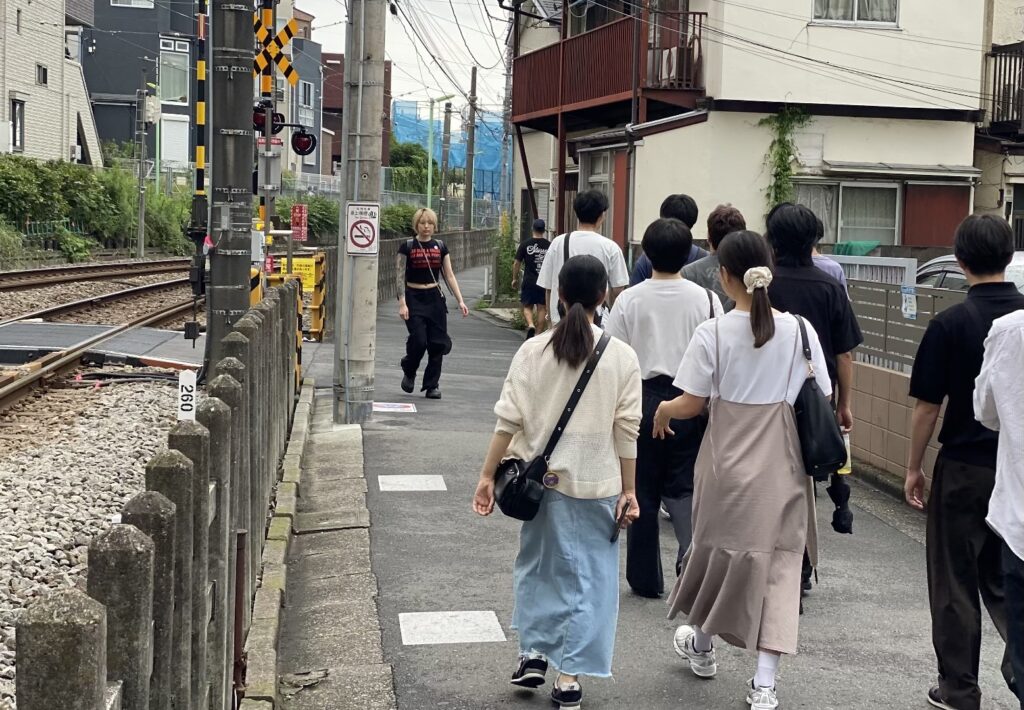東急世田谷線沿いの細い路地を歩く参加者