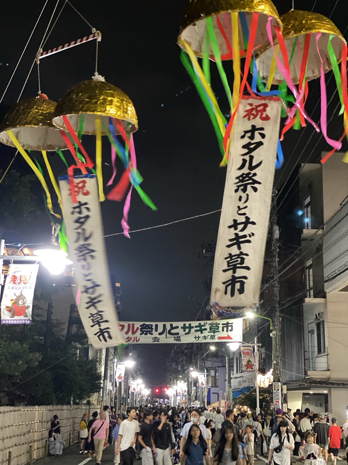 夜のせたがやホタル祭りとサギ草市の会場入口を飾るくす玉と通りのにぎわい