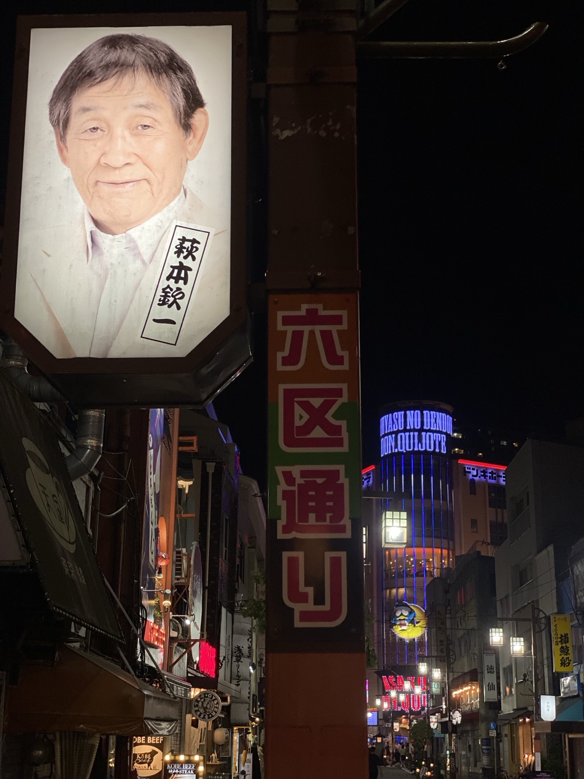 浅草六区通りの萩本欽一さんの看板と夜の浅草の街並み