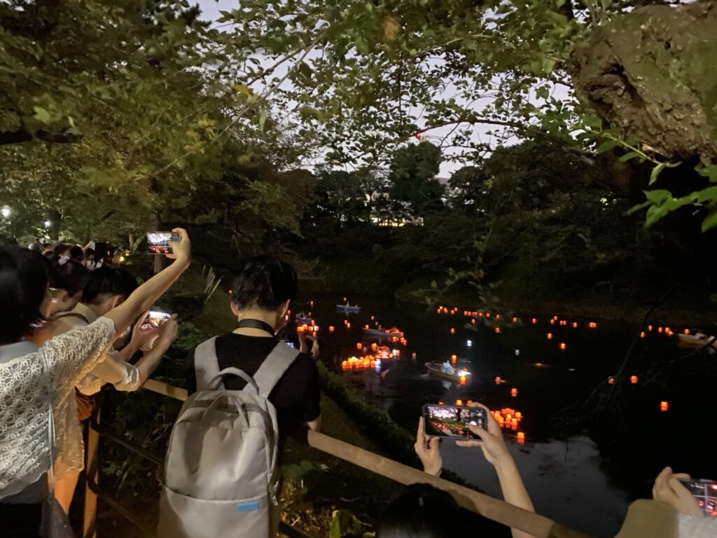千鳥ヶ淵緑道から灯ろう流しを撮影する来場者