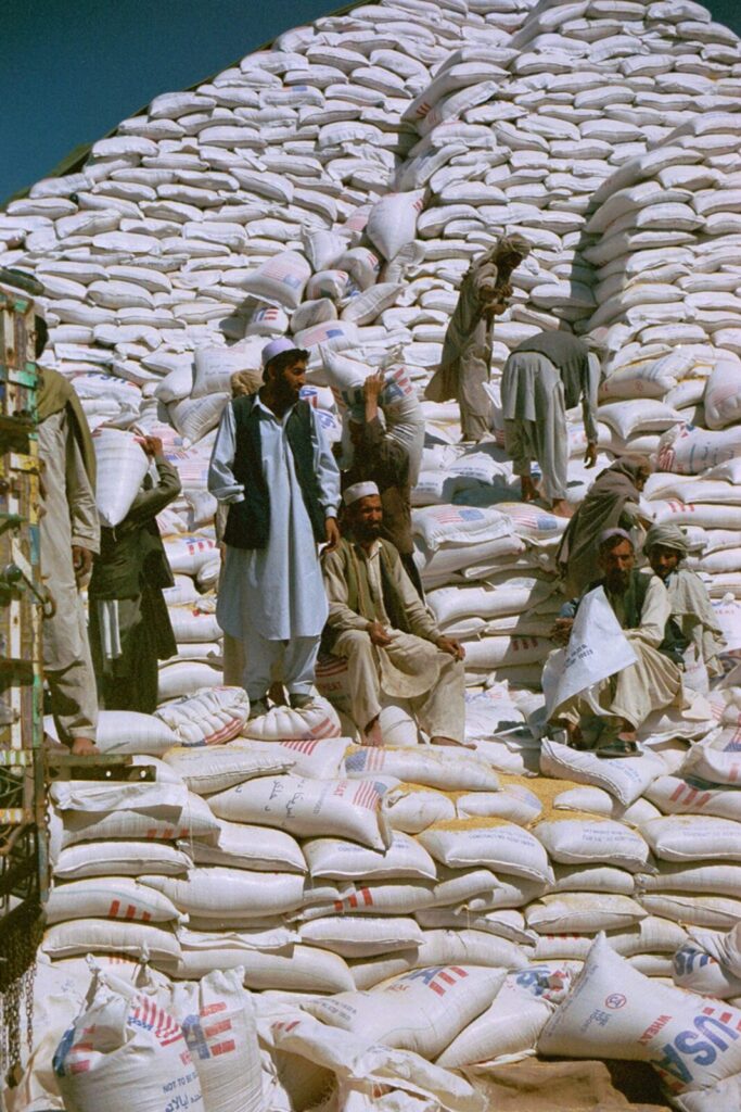 2002年、USAIDが提供した小麦を積み上げるアフガニスタンの作業員