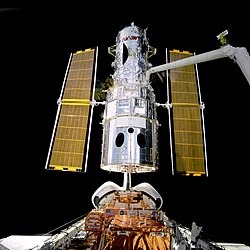 STS-82でロボットアームに保持されたハッブル