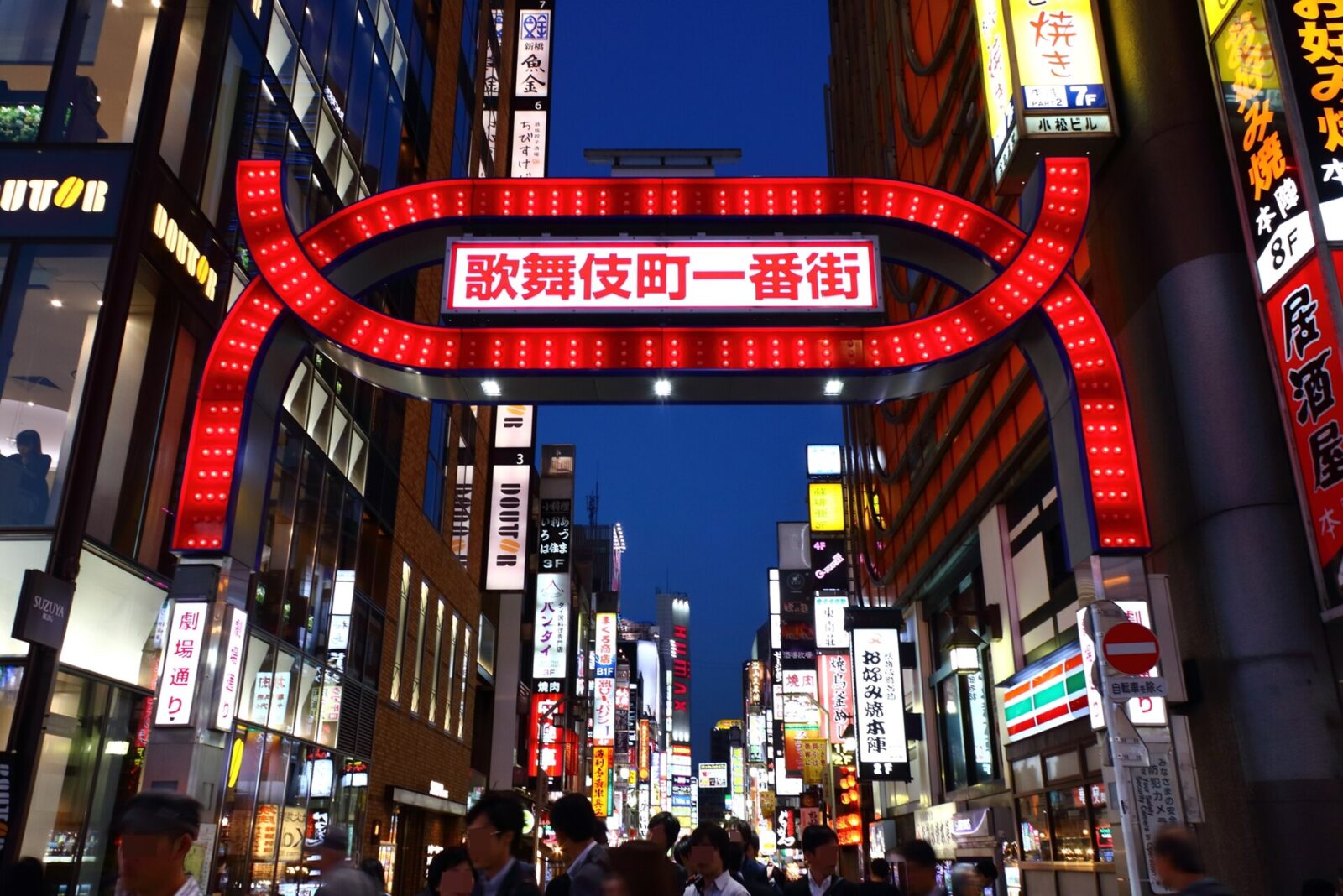 夜の歌舞伎町一番街入口に立つ赤いアーチと繁華街の照明