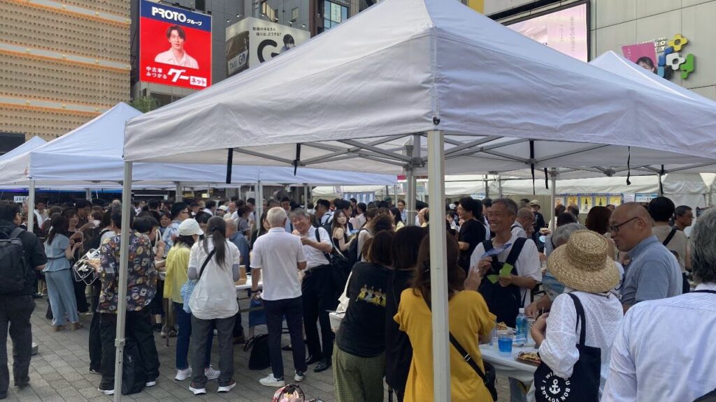 新橋こいち祭の明るい時間帯にテント周辺へ集まる来場者