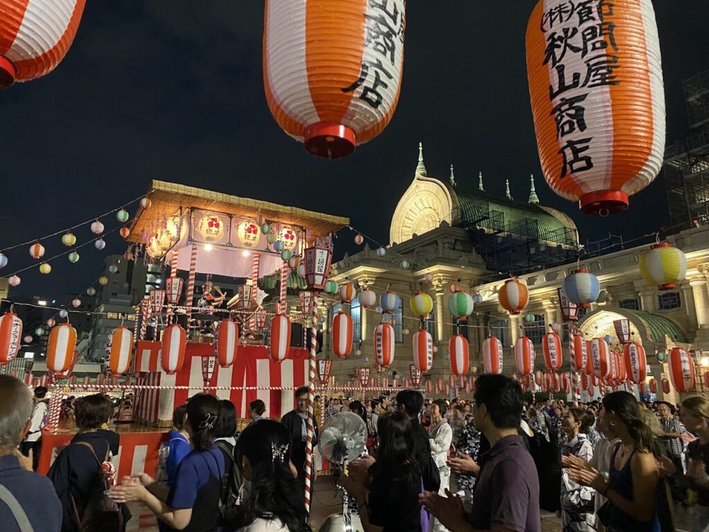 櫓と築地本願寺本堂を囲む盆踊りの輪