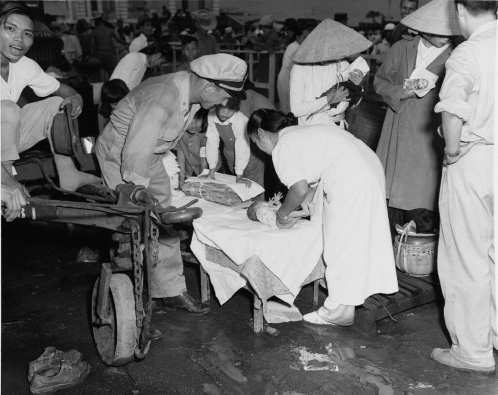 1954年8月、ハイフォン近郊の難民収容所で乳児を世話するベトナム人看護師
