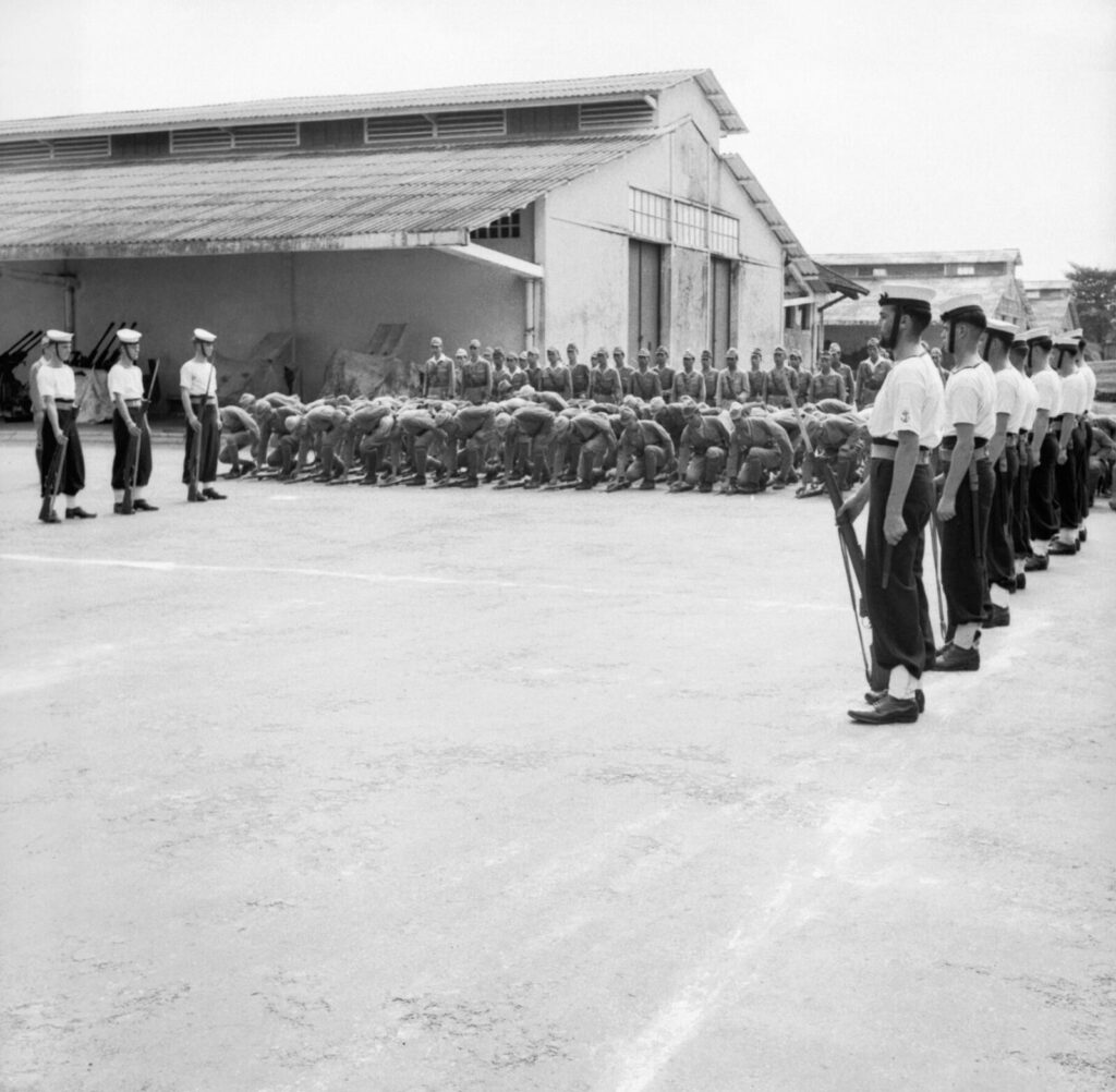 1945年、サイゴンの降伏式典で武器を置く日本海軍兵