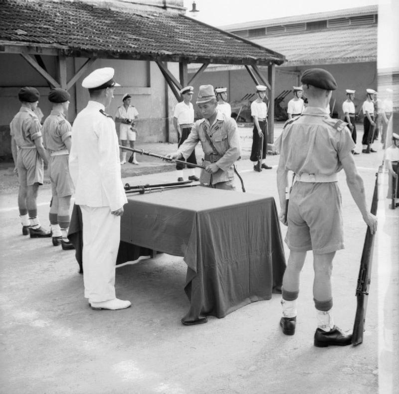 1945年、サイゴンの降伏式典で軍刀を引き渡す日本海軍准士官