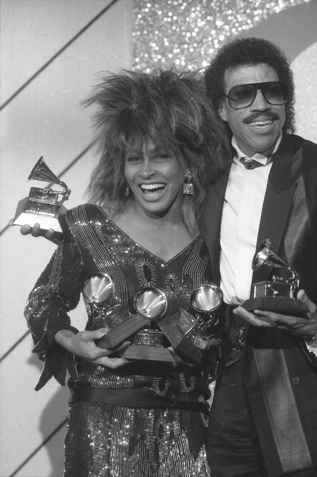 1985年のグラミー賞でトロフィーを持つライオネル・リッチーとティナ・ターナー
