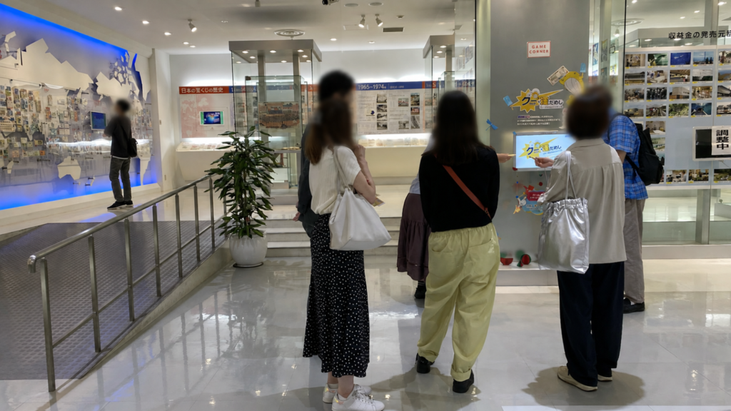 東京宝くじドリーム館の体験ゲーム「クー運試し」を楽しむ参加者