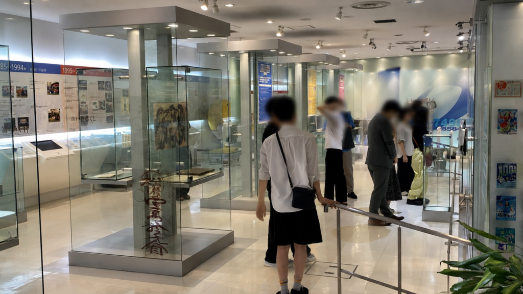 東京宝くじドリーム館の宝くじ年表と歴史展示を見学する参加者