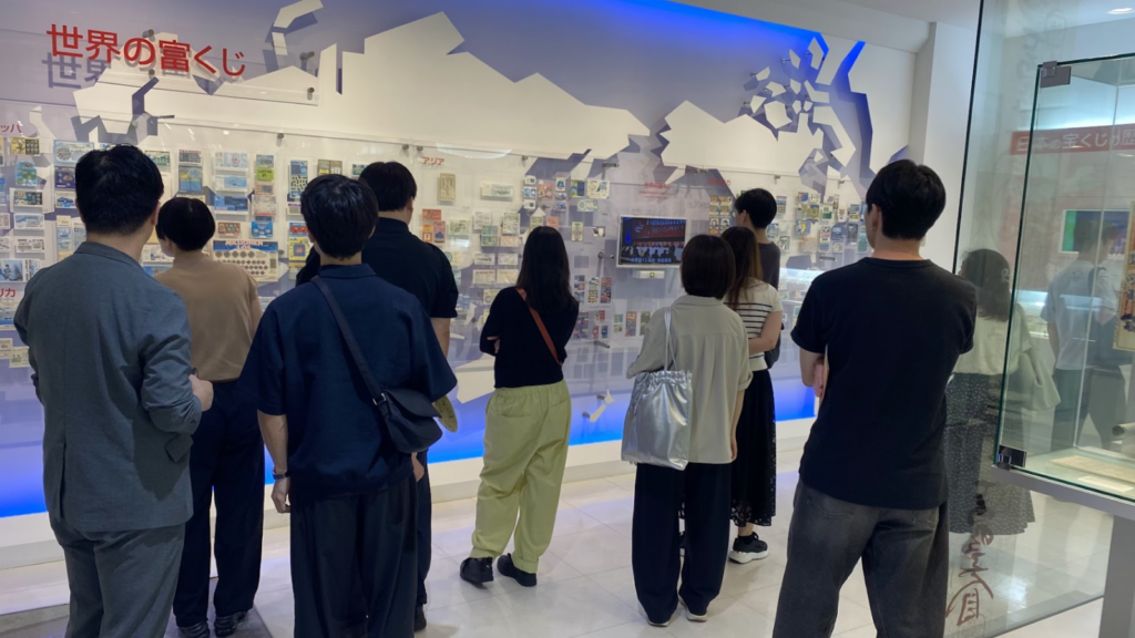 東京宝くじドリーム館の「世界の富くじ」展示を見学する参加者