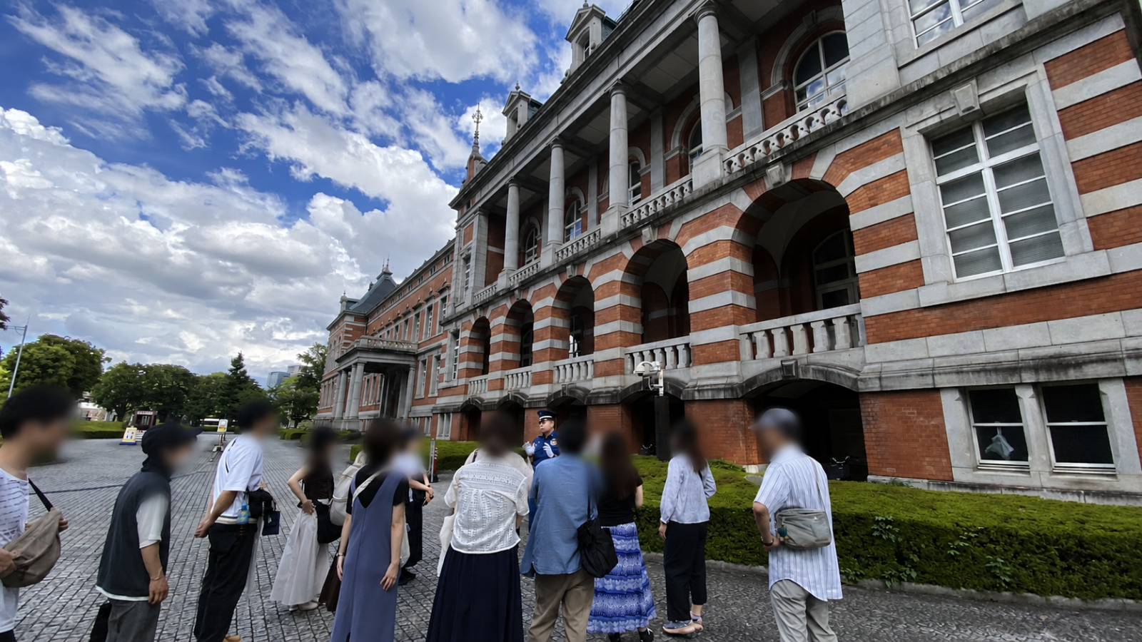 法務省旧本館(赤れんが棟)前でガイド説明を聞く参加者