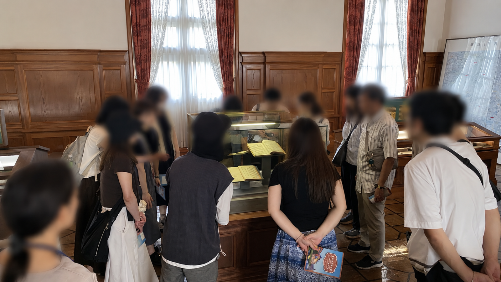 法務史料展示室で展示資料のガイド解説を聞く参加者