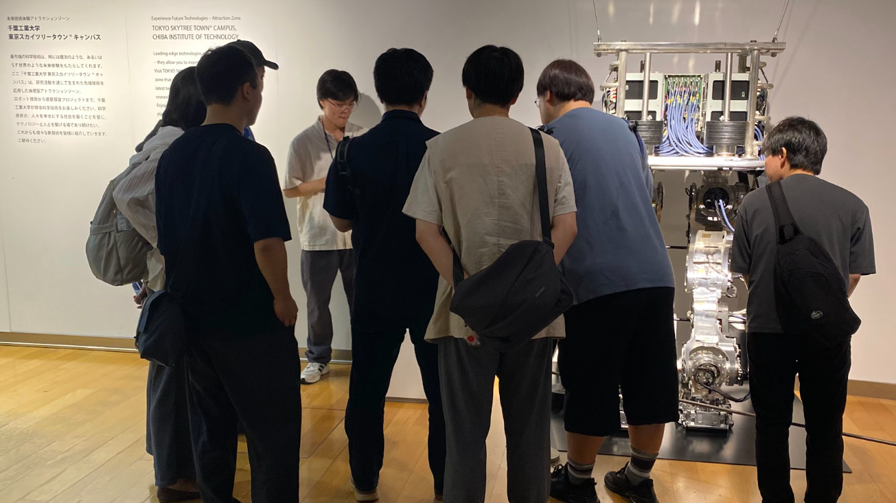 千葉工業大学 東京スカイツリータウンキャンパスで先端技術展示の解説を聞く参加者