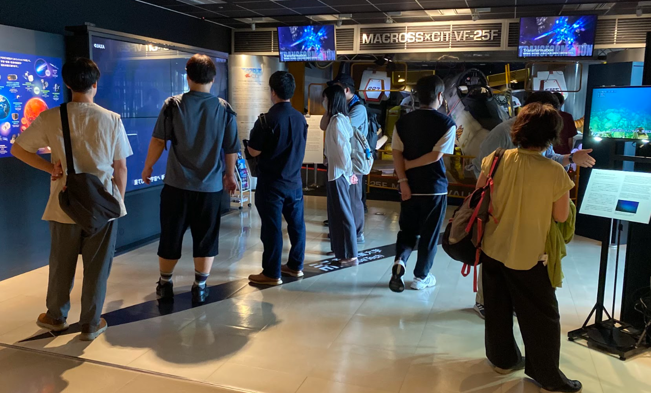 千葉工業大学 東京スカイツリータウンキャンパスでマクロス展示を見学する参加者