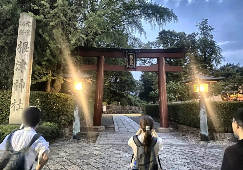 夕暮れの根津神社表参道鳥居と参拝する参加者