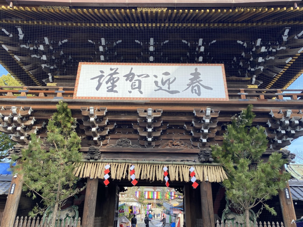 迎春の額が掲げられた西新井大師山門