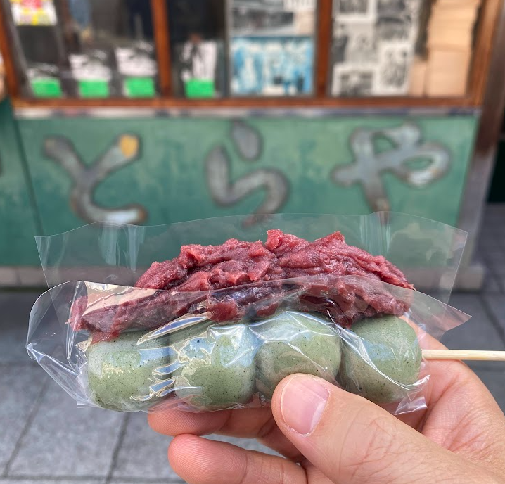 柴又名物の草だんごを手にした様子