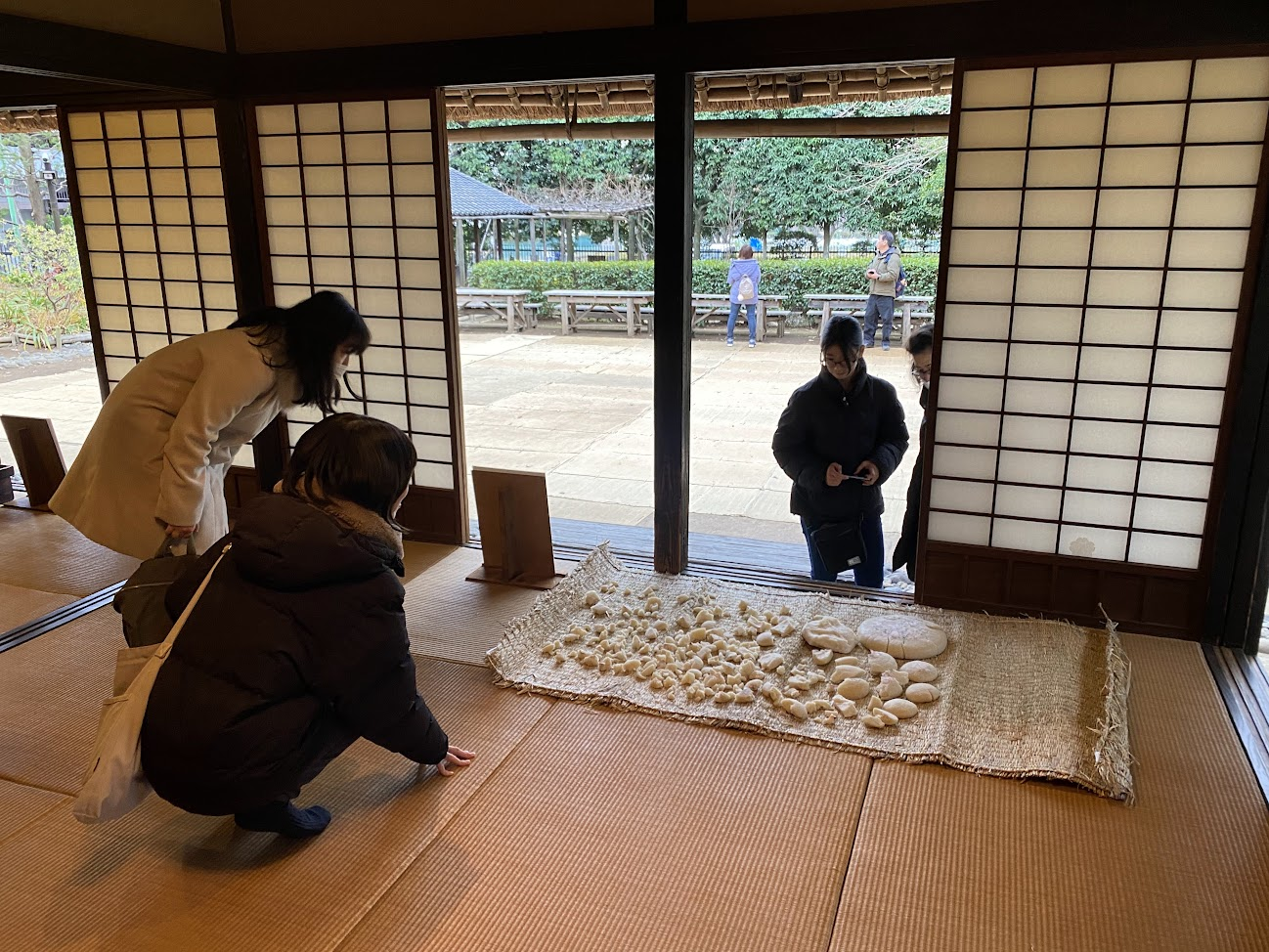 岡本公園民家園の餅の展示を見学する参加者