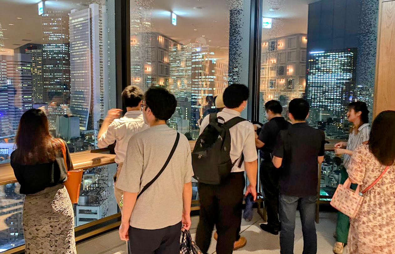 東急歌舞伎町タワー館内から新宿の夜景を眺める参加者