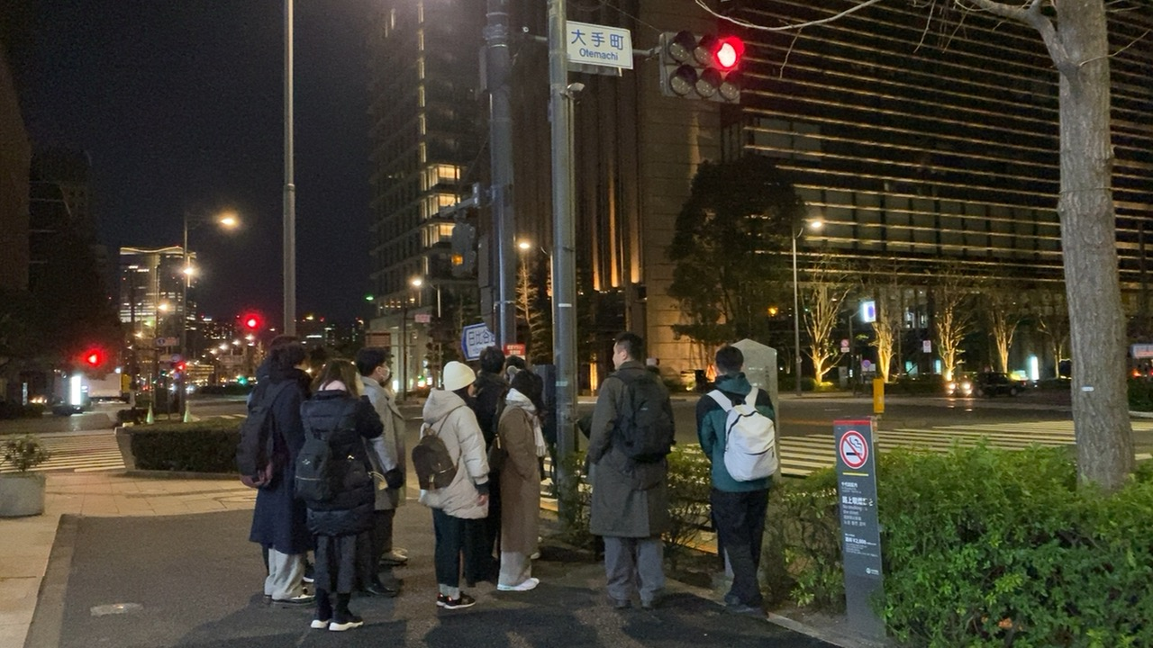 夜の大手町交差点を歩くゆる歴史散歩会の参加者