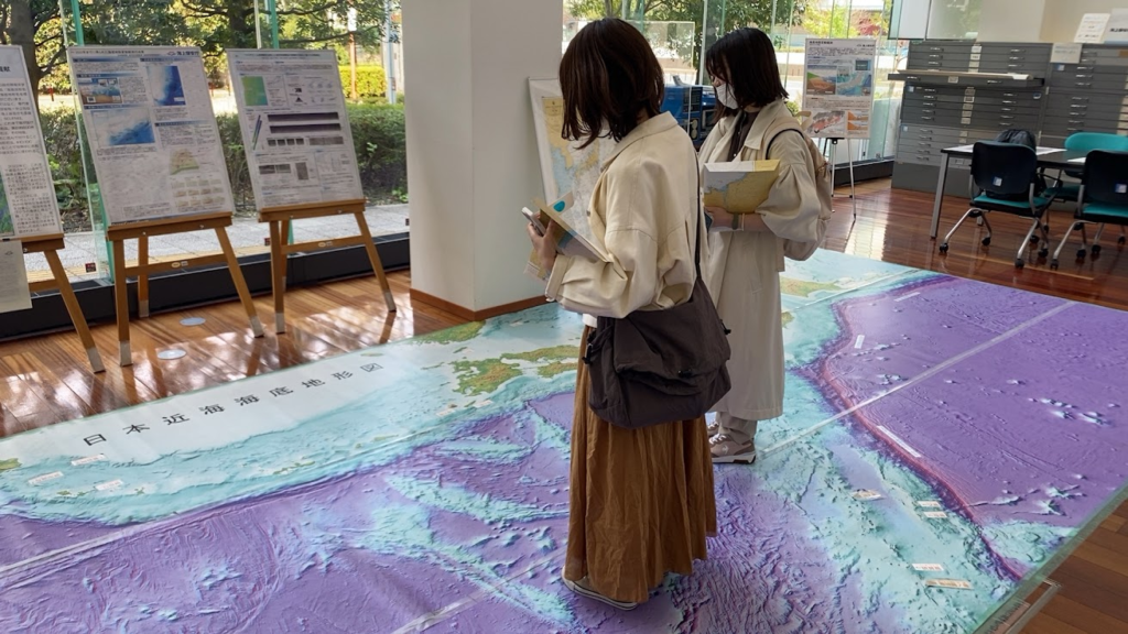 大型3D海底地形図の上で日本近海の海底地形を見る参加者