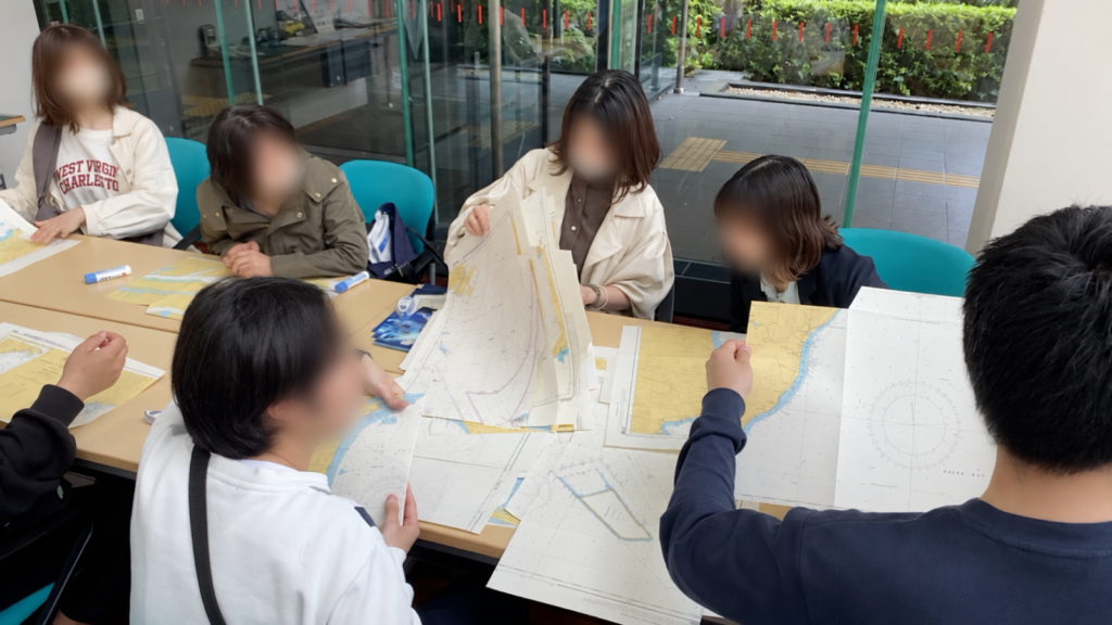 古い海図を囲んで紙袋工作を楽しむ参加者