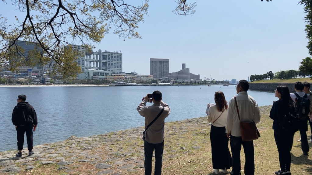 お台場海浜公園から海越しに品川台場周辺を眺める参加者
