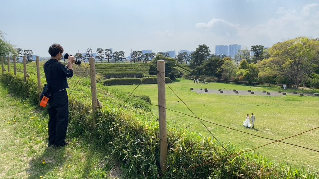 第三台場の土塁上から史跡を撮影する参加者