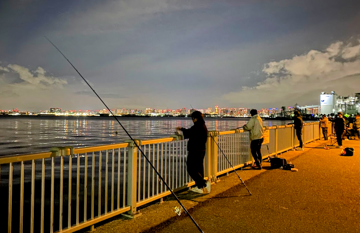夜の若洲海浜公園海釣り施設で釣りを楽しむ人々