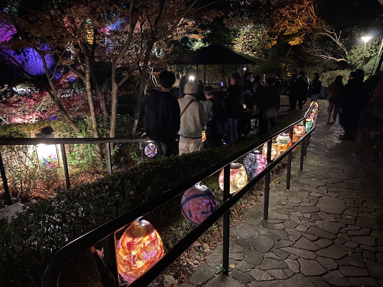 目白庭園の園路に並ぶ色とりどりの灯籠と来園者