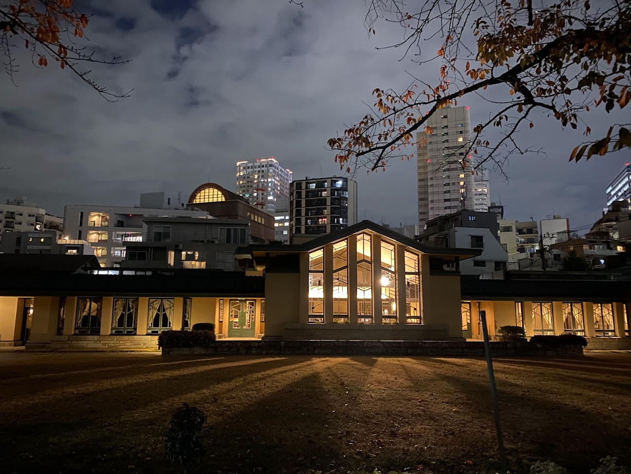夜の自由学園明日館中央棟と幾何学的なホール窓