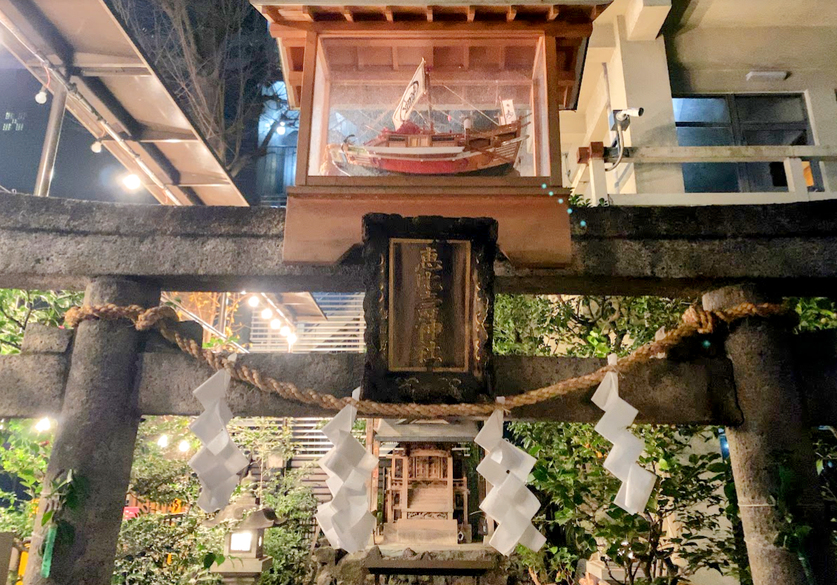 夜の稲荷鬼王神社の鳥居と境内社、上部に掲げられた船の模型