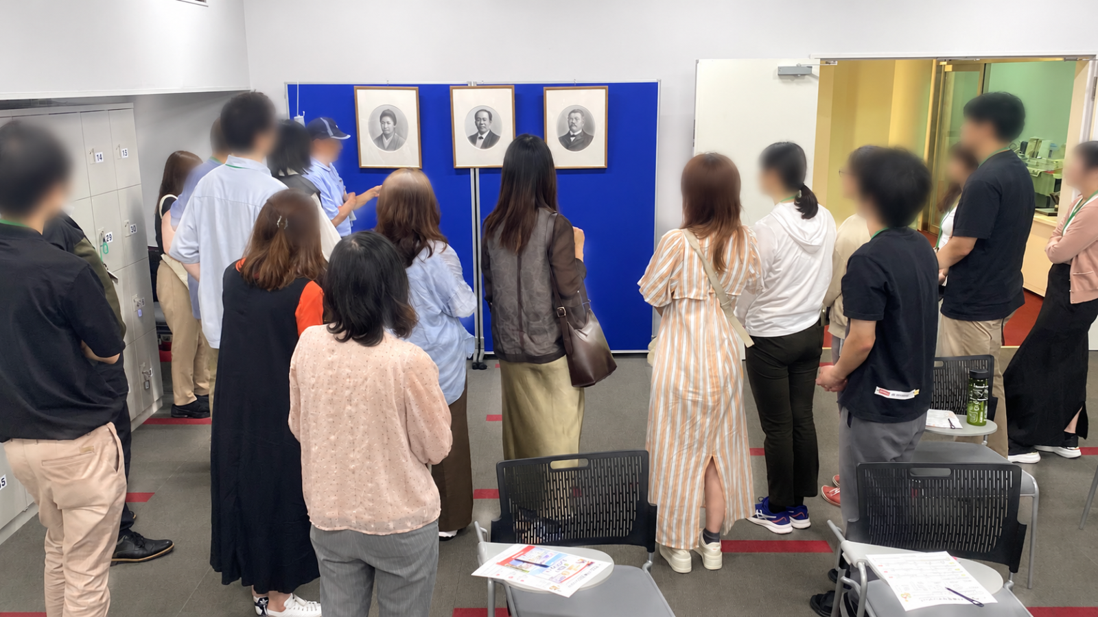 国立印刷局東京工場の展示室で職員の説明を聞く見学者