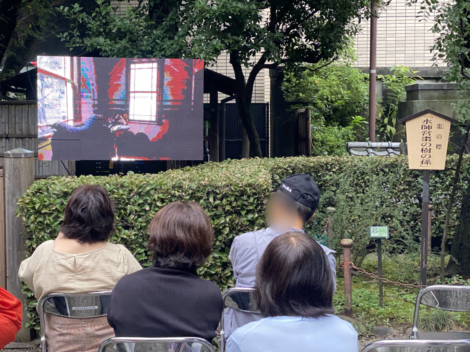 旧乃木邸前の屋外映像解説を見る参加者