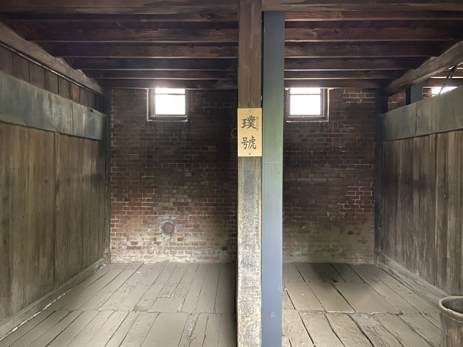 煉瓦壁と木造の仕切りが残る旧乃木邸馬小屋内部